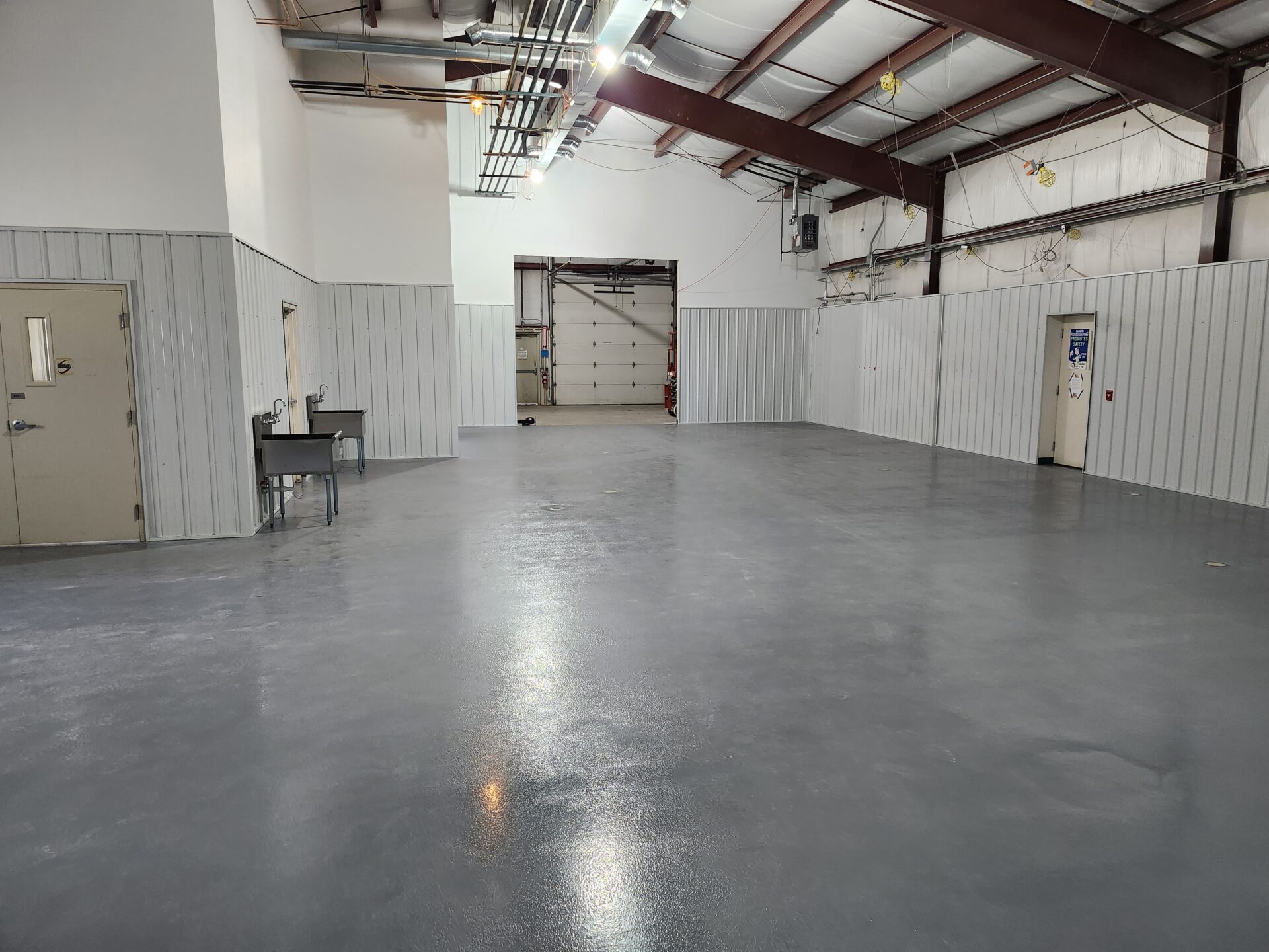 Spacious industrial garage with shiny concrete floor.