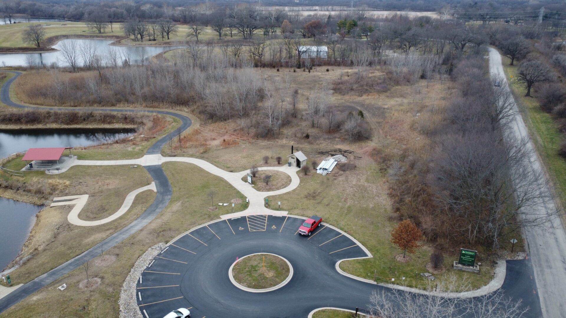 Aerial view of park with winding paths and small lakes.