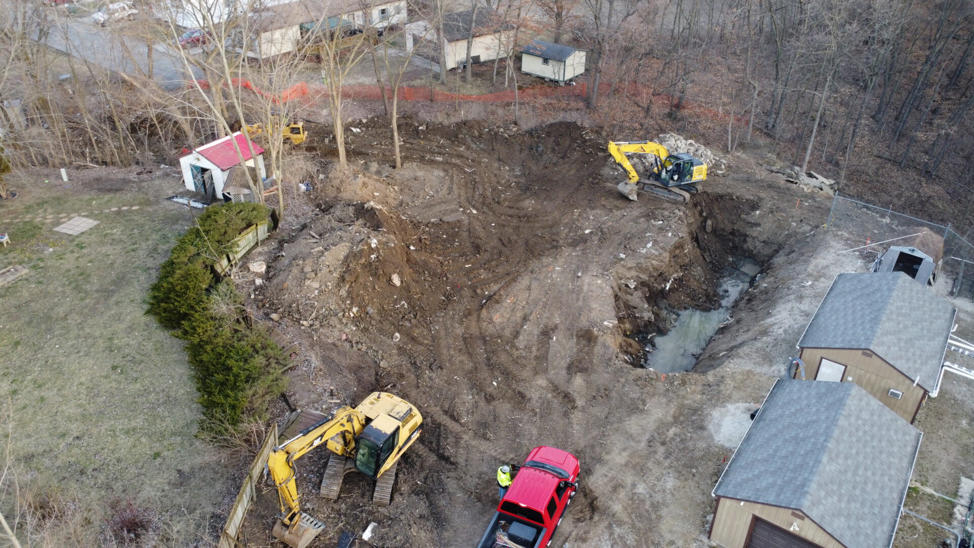 Aerial view of construction site with excavators and vehicles.