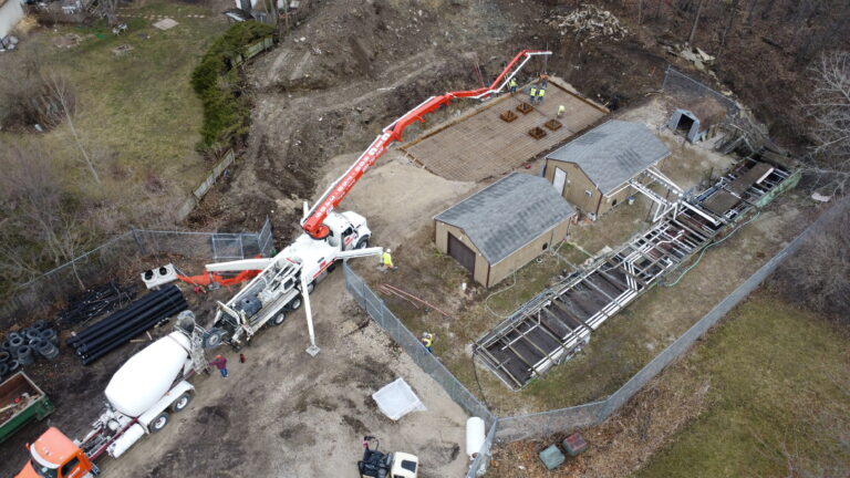 Aerial view of construction site with concrete pouring activity.
