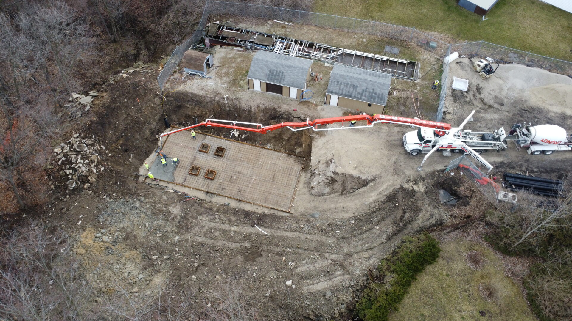 Aerial view of construction site with concrete pump truck.
