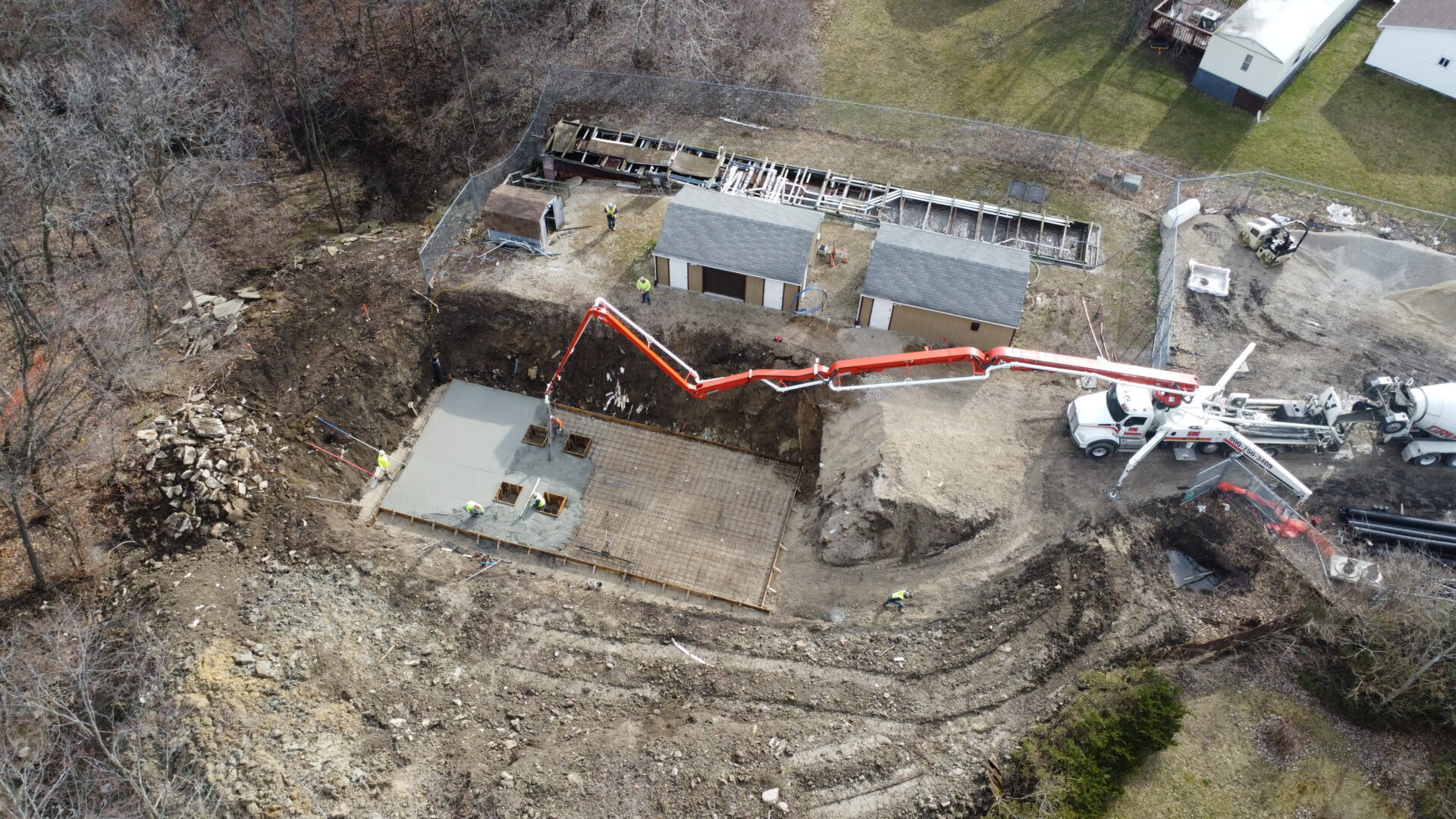 Aerial view of construction site with concrete pouring machinery.
