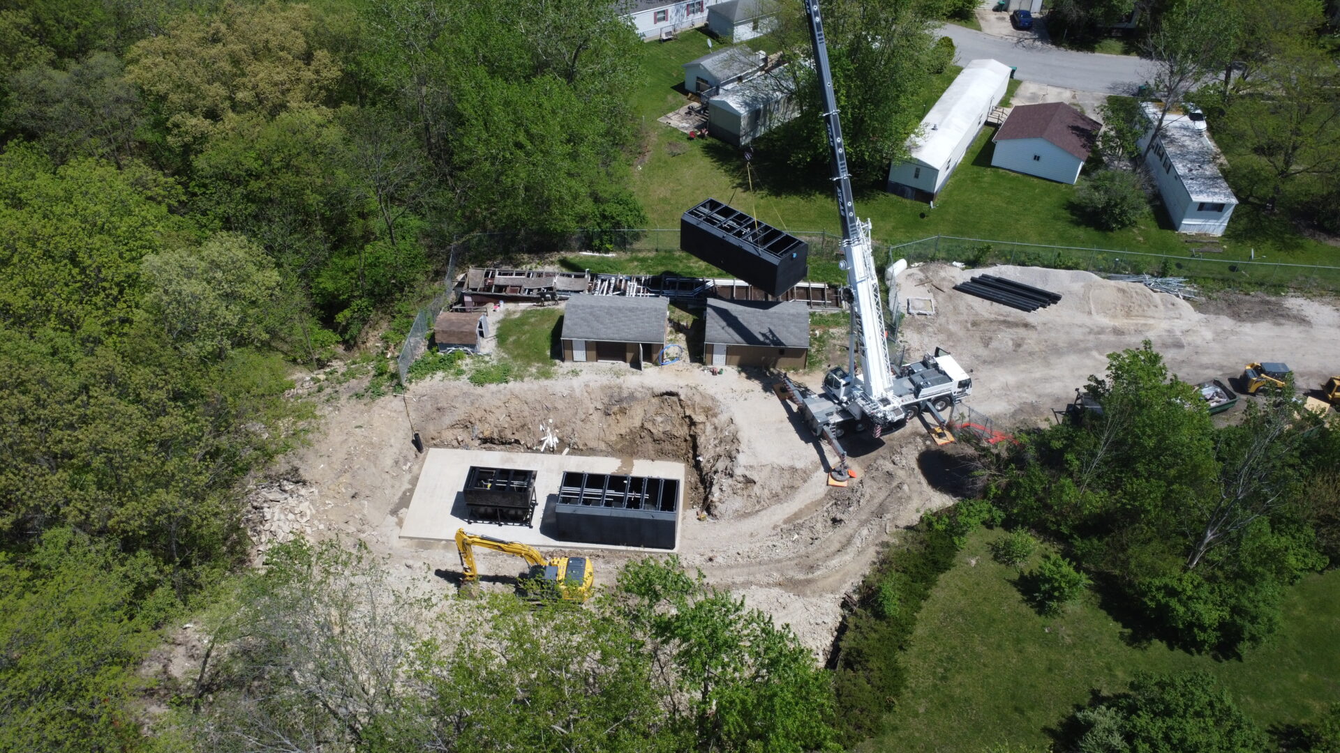 Aerial view of residential construction site with crane.