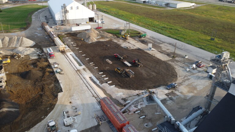 Aerial view of active construction site with machinery and trucks.