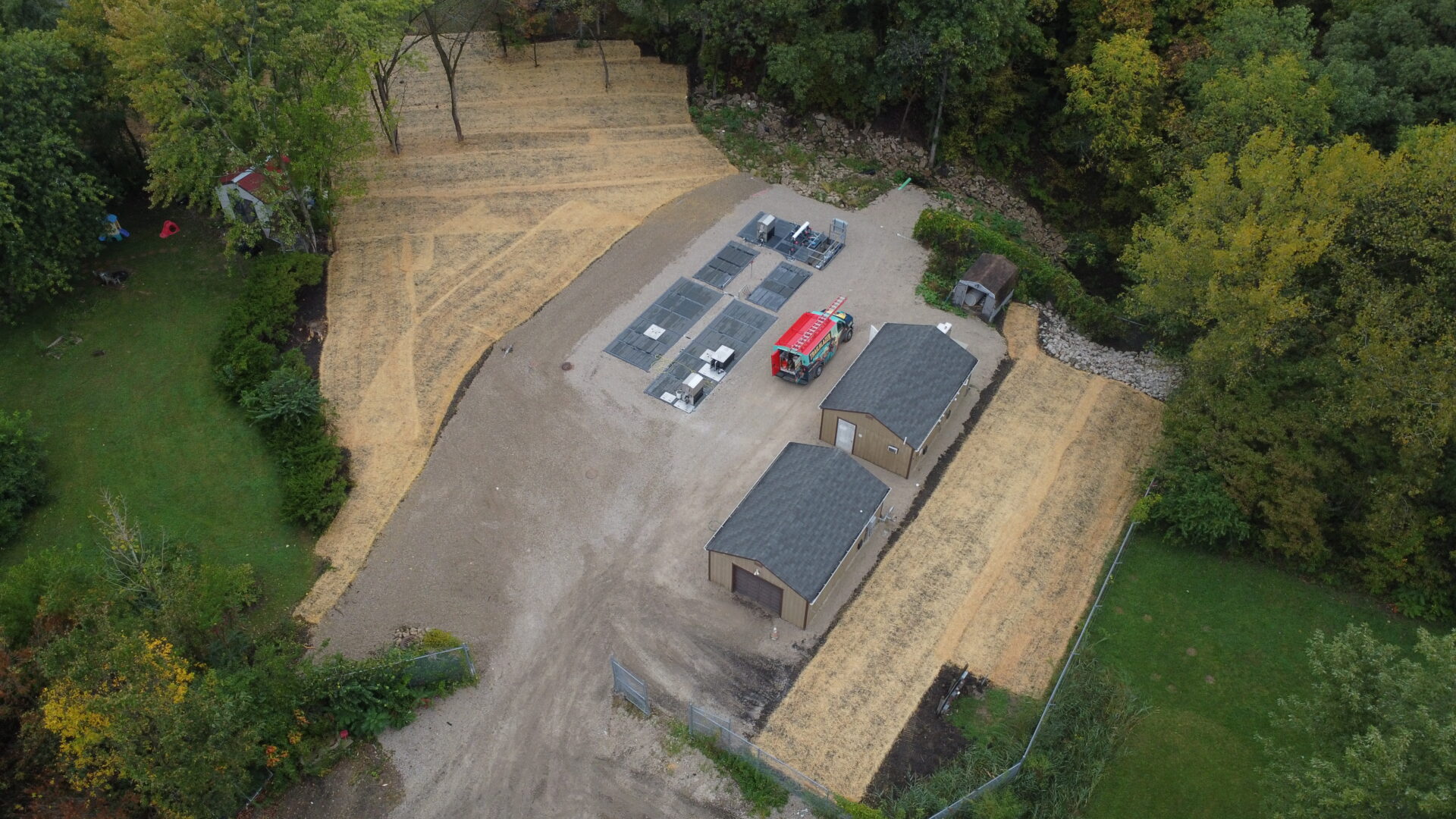 Aerial view of rural backyard with buildings and truck.