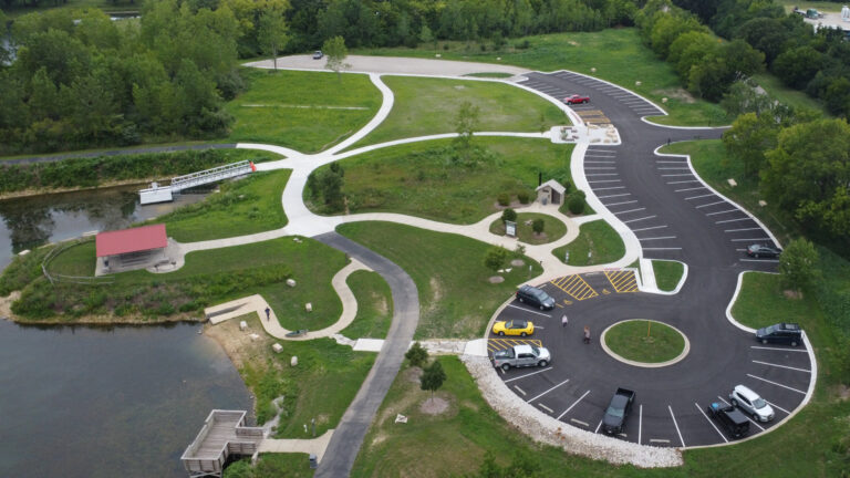 Aerial view of a park with winding paths and parking.